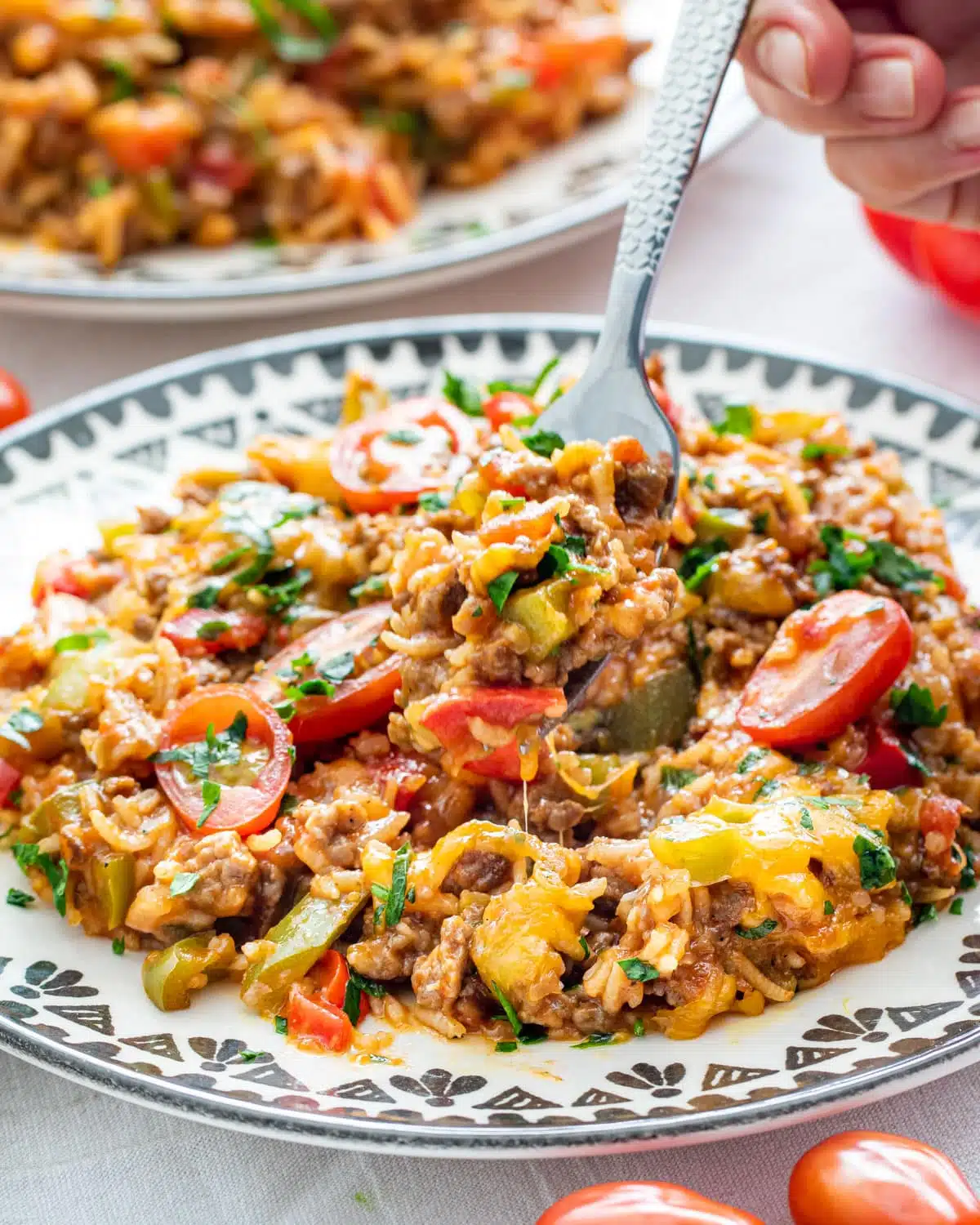 a fork lifting some stuffed pepper casserole from a white plate
